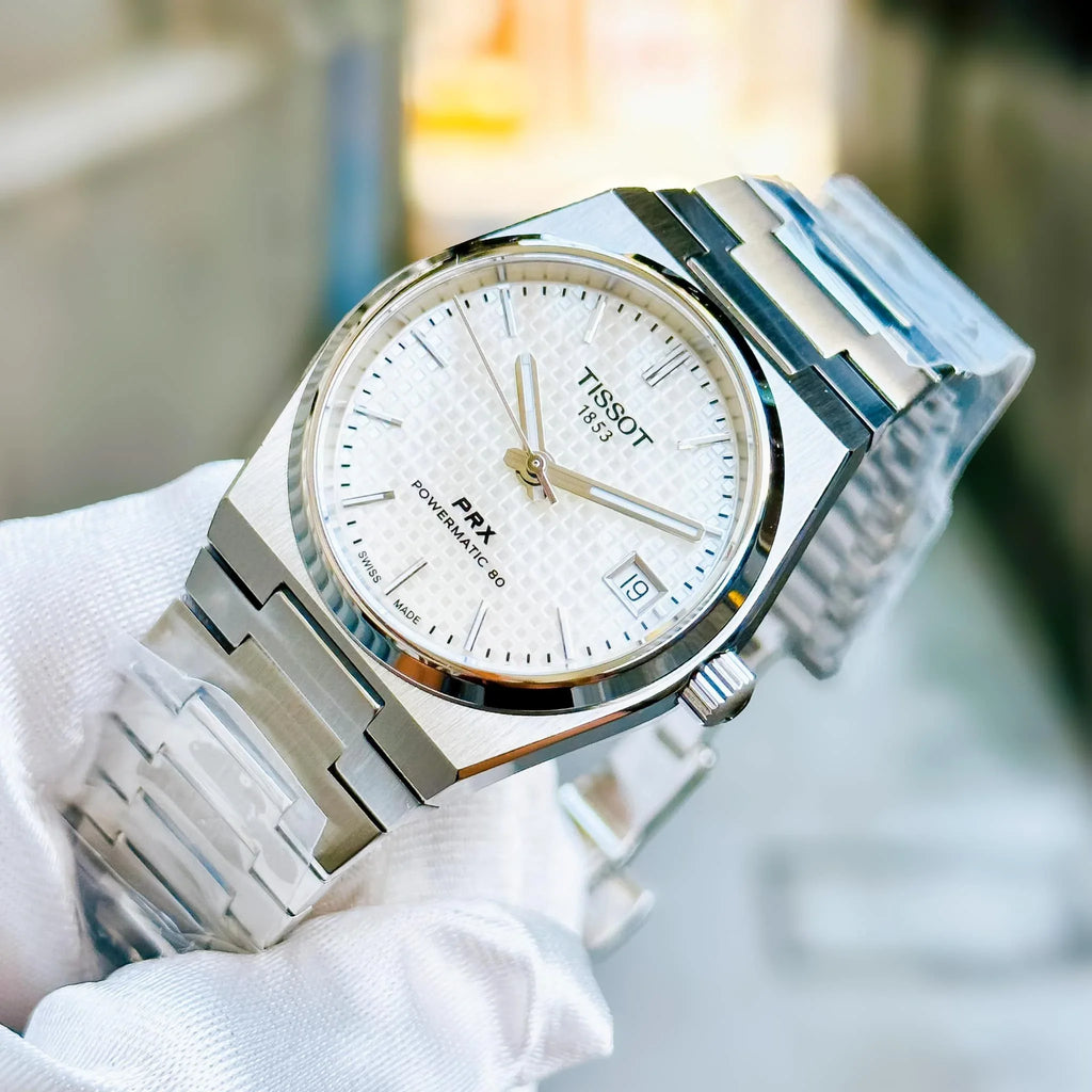 Tissot watch with silver case and mother-of-pearl dial on a wooden surface