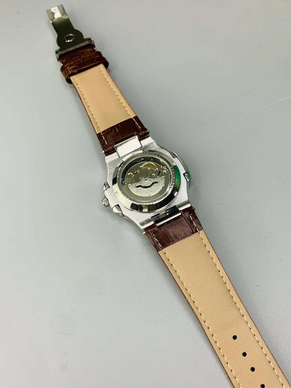 Watch with a brown strap on a gray background