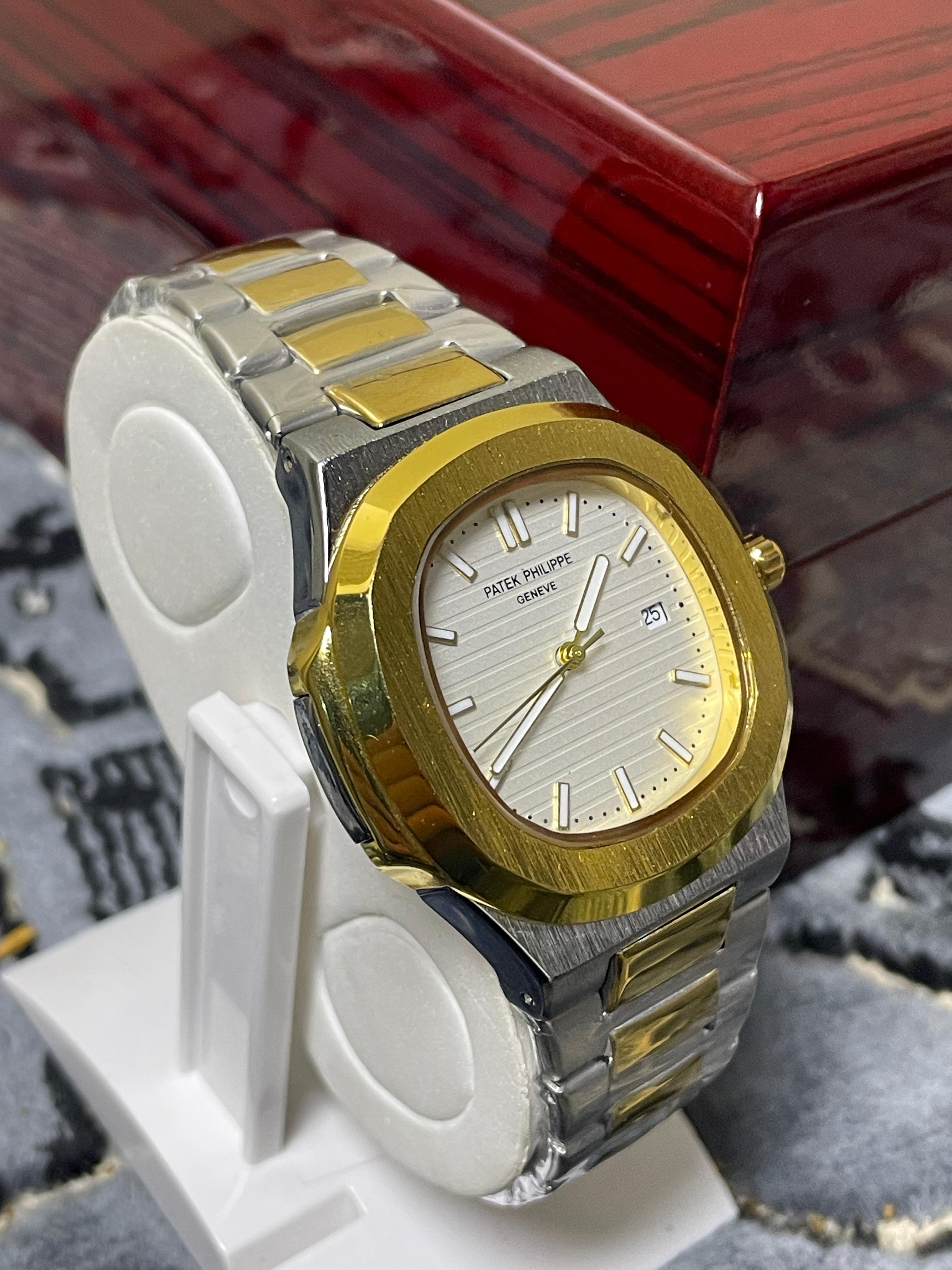 Gold and silver watch on a white stand with a red background