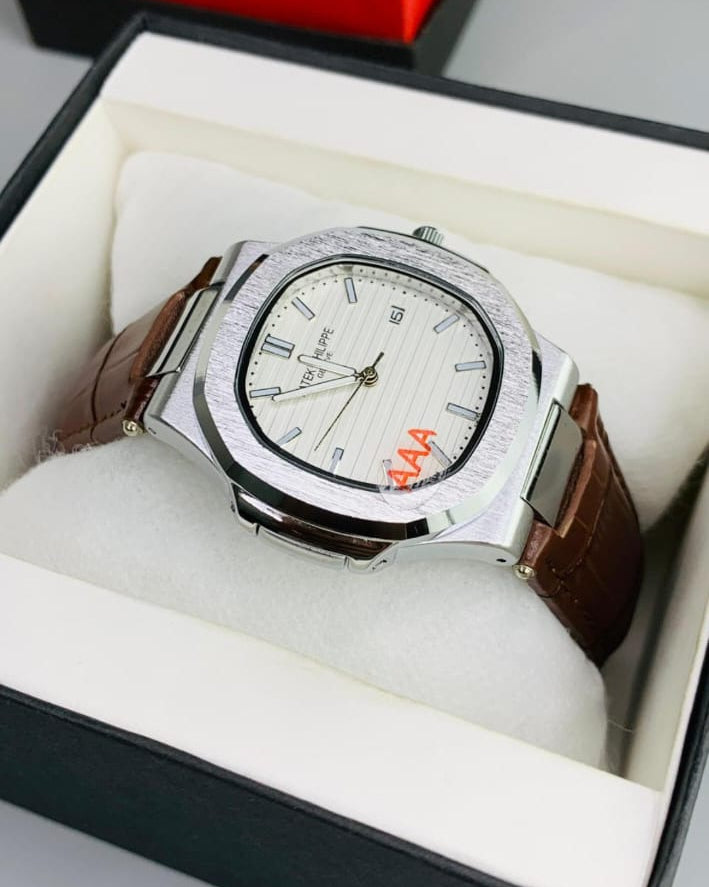 Watch with brown leather strap in a box on a gray surface